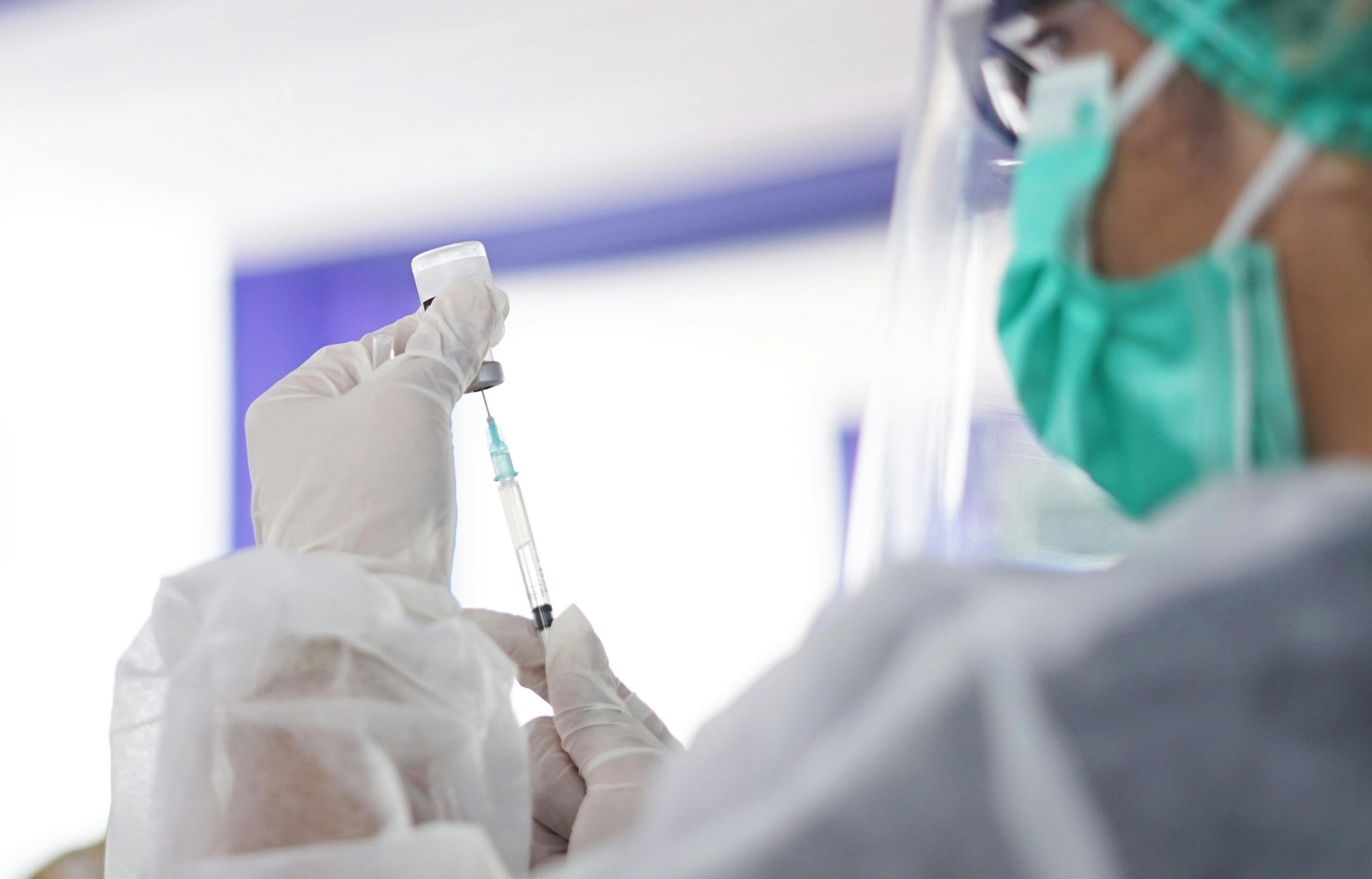 A healthcare worker preparing a syringe with vaccine, showcasing medical precision.